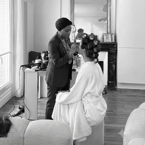 Linda maquille une mariée en peignoir, bigoudis dans les cheveux, le jour de son mariage