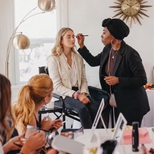 Linda maquille une cliente dans un salon élégant au cours d’une master class